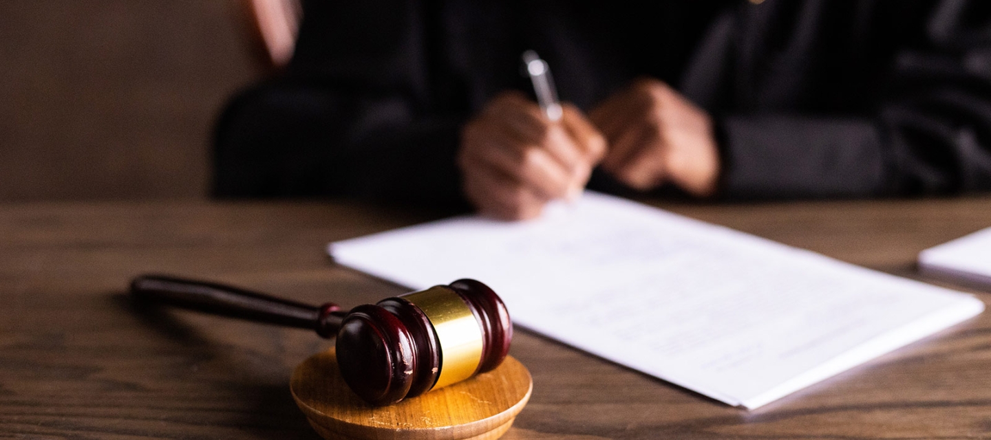 Gavel with person writing in the background